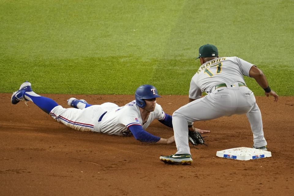 Texas Rangers' Brad Miller is tagged out at second by Oakland Athletics shortstop Elvis Andrus (17) after Miller hit a two-run single in the first inning of a baseball game, Wednesday, July 13, 2022, in Arlington, Texas. Miller was attempting to advance to second on the play that scored Jonah Heim and Leody Taveras. (AP Photo/Tony Gutierrez)