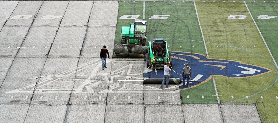 Workers tear up the old turf at InfoCision Stadium on Thursday, June 9. The new field will be installed in time for football season with updated branding.