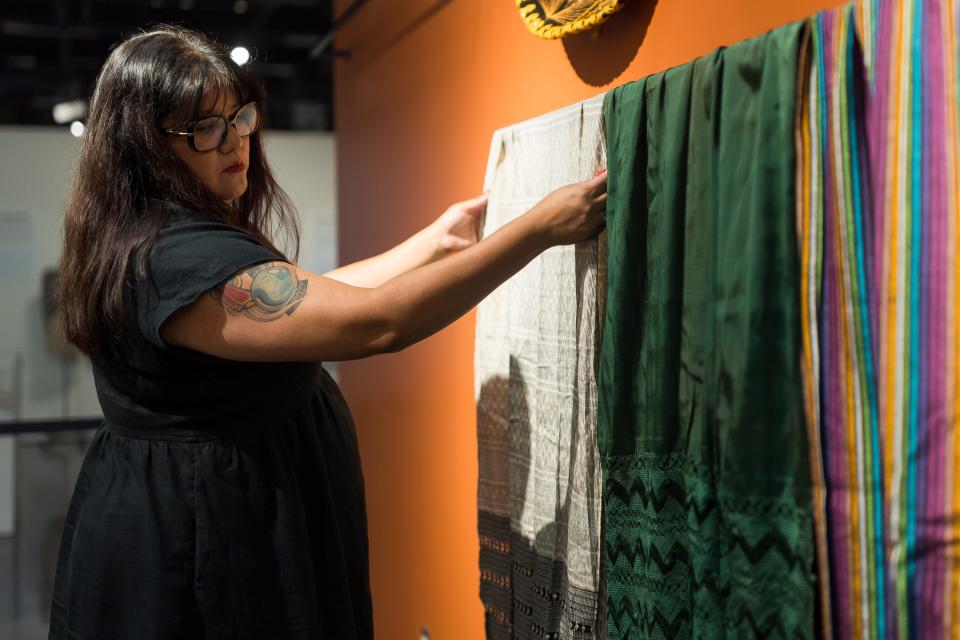 Director of the El Paso Museum of History Erica Marin hangs textile pieces for the “Mexicanidad: Folklorizing a Nation 1921-1971,” exhibit on the history and crafts made after the Mexican Revolution by Indigenous artisans. The show will run through Feb. 24, 2024.