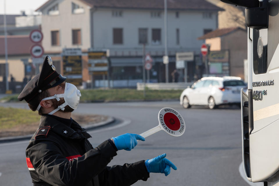 GUARDAMIGLIO, ITALY - FEBRUARY 24: An Italian Carabinieri officer, wearing a respiratory mask, talks to a truck driver (not in the picture) at a road block on February 24, 2020 in Guardamiglio, south-west Milan, Italy. Guardamiglio is a town nearby one of the ten small towns placed under lockdown after coronavirus sparked infections throughout the Lombardy region. Italy is the last country to be hit hard by the virus with 6 dead and more than 229 infected as of today. The spread marks Europe’s biggest outbreak, prompting Italian Government to issue draconian safety measures. (Photo by Emanuele Cremaschi/Getty Images)