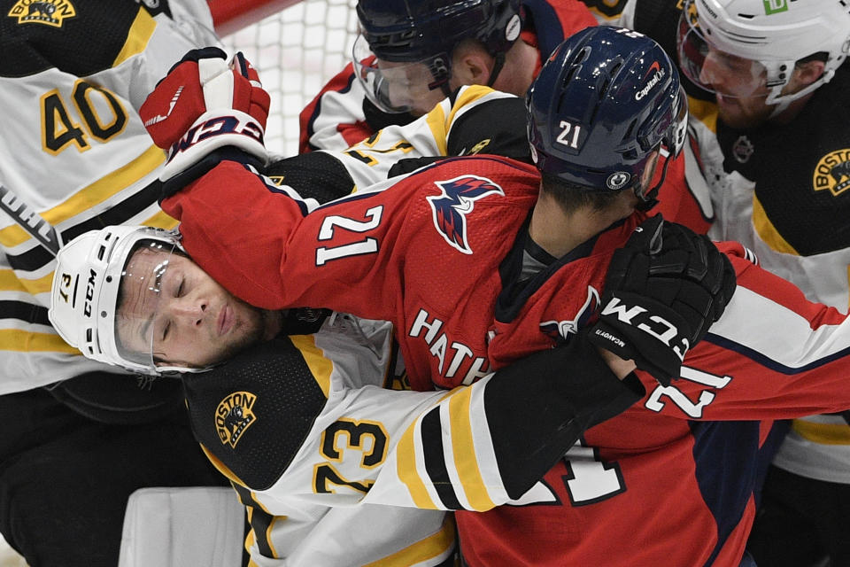 Washington Capitals right wing Garnet Hathaway (21) and Boston Bruins defenseman Charlie McAvoy (73) scuffle during the first period in Game 5 of an NHL hockey Stanley Cup first-round playoff series, Sunday, May 23, 2021, in Washington. (AP Photo/Nick Wass)