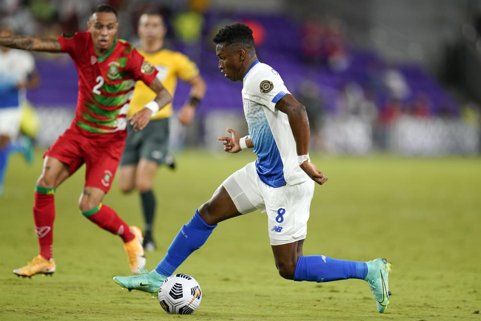 Bryan Oviedo, de Costa Rica, avanza frente a Damil Dankerlui, de Surinam, en un partido de la Copa de Oro disputado el viernes 16 de julio de 2021 en Orlando (AP Foto/John Raoux)