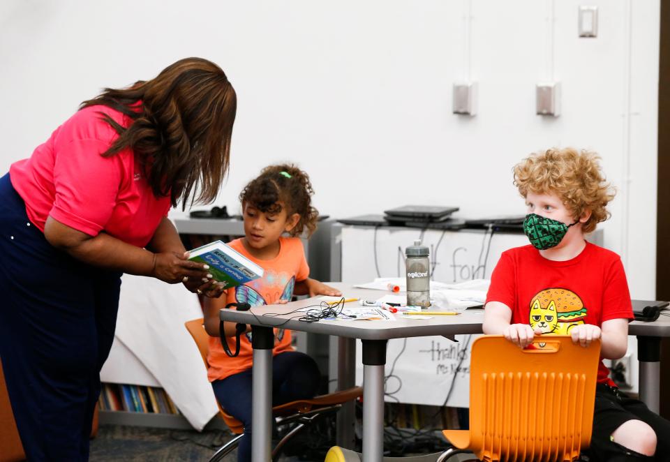 Superintendent Grenita Lathan shows a book to children during a summer class at Sunshine Elementary. Summer reading was a focus this year with the district giving away take-home books to children in the early grades.