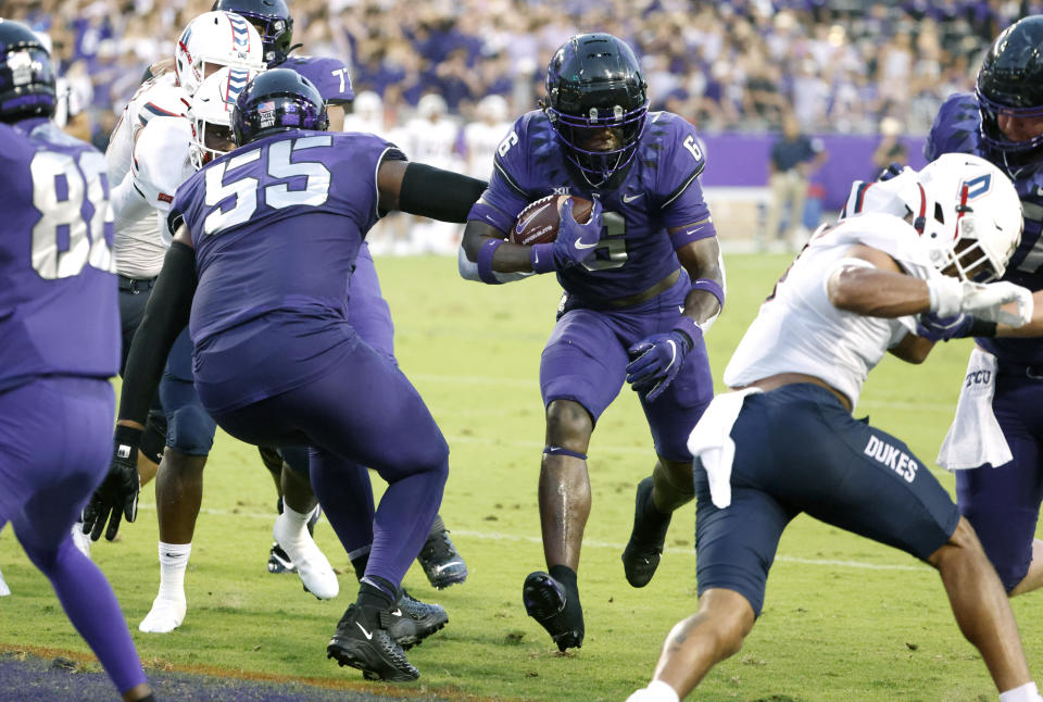 TCU running back Zach Evans (6) runs the ball in for a touchdown behind the block of offensive tackle Obinna Eze (55) against Duquesne during the first half of an NCAA college football game Saturday, Sept. 4, 2021, in Fort Worth, Texas. (AP Photo/Ron Jenkins)