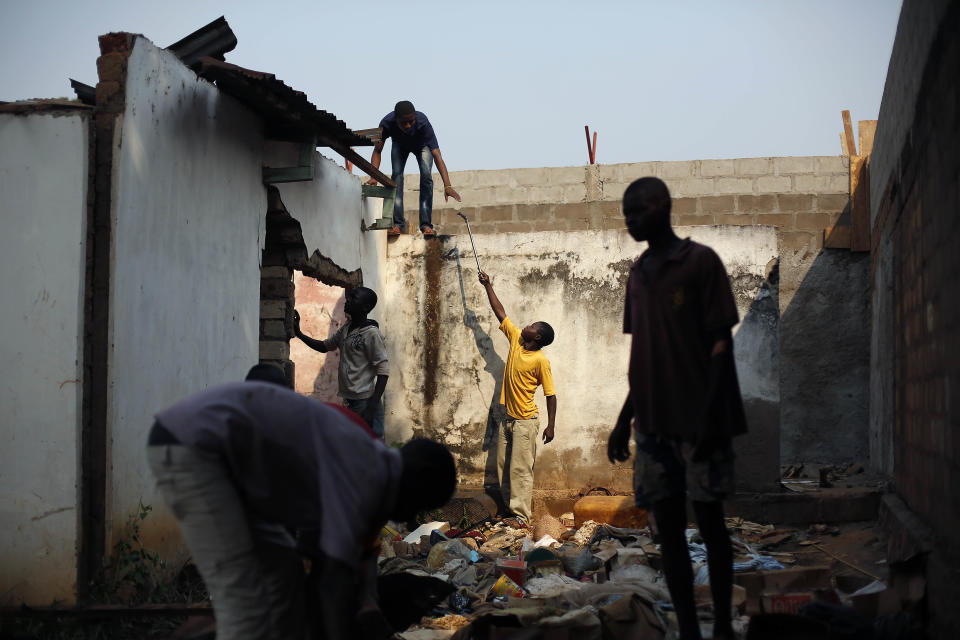 Looters take down the metal roofs from the mosque at the Place de la Reconciliation in the Miskin district of Bangui, Central African Republic, Wednesday Jan. 29, 2014. Fighting between rival Muslim Seleka factions and Christian anti_Balaka militias continues, as two Muslim men were slaughtered by unknown assailants with machetes nearby, prompting French forces to fire warning shots in the air but not intervene to try to prevent the killings. (AP Photo/Jerome Delay)