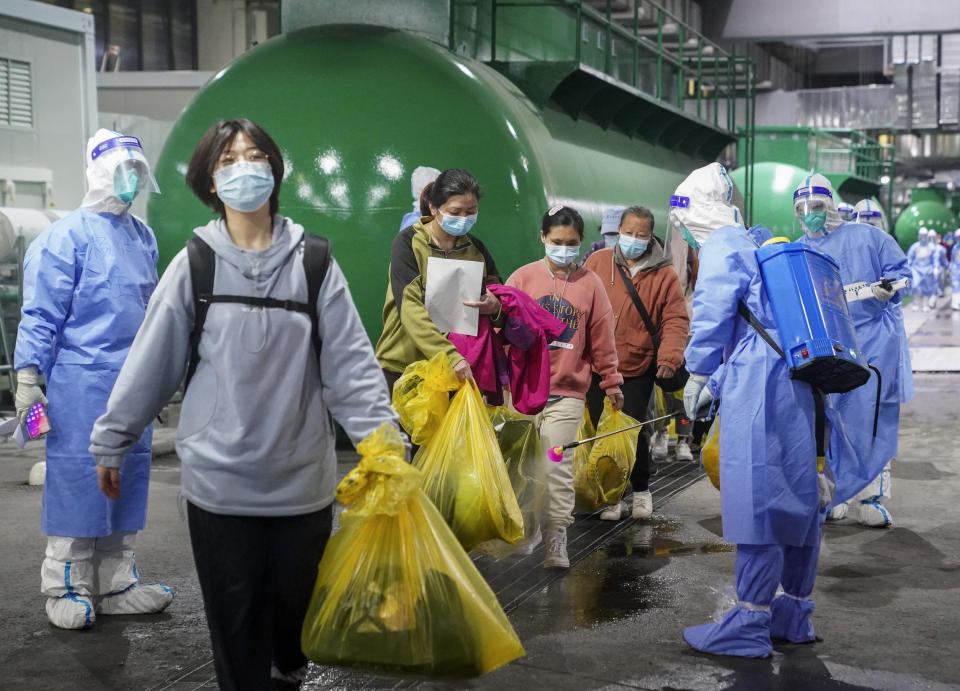 In this photo released by China's Xinhua News Agency, COVID-19 patients leave a makeshift hospital at the National Exhibition and Convention Center in Shanghai, Thursday, April 14, 2022. Anti-virus controls that shut down some of China's biggest cities and fueled public irritation are spreading as infections rise, hurting a weak economy and prompting warnings of possible global shockwaves. (Ding Ting/Xinhua via AP)