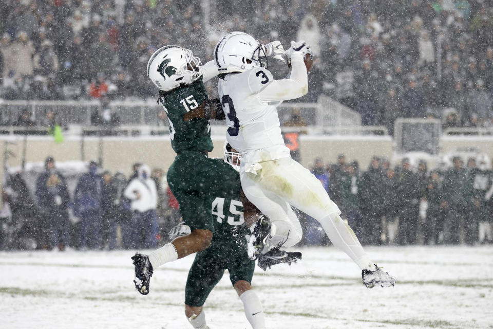 Penn State's Parker Washington, right, catches a pass in the end zone for a touchdown against Michigan State's Angelo Grose (15) during the fourth quarter of an NCAA college football game, Saturday, Nov. 27, 2021, in East Lansing, Mich. Michigan State won 30-27. (AP Photo/Al Goldis)