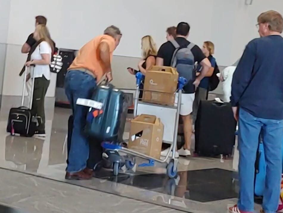 Greene looking at her phone at baggage claim at the airport in Liberia, Costa Rica on Sunday.