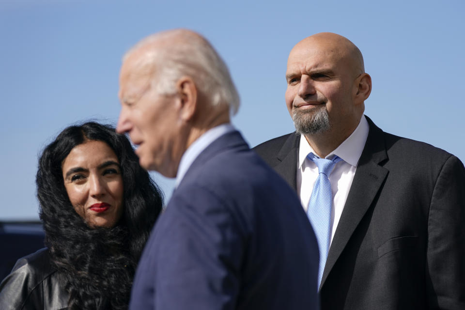 Pennsylvania Lt. Gov. John Fetterman, right, a Democratic candidate for U.S. Senate, and his wife Gisele Barreto Fetterman stand on the tarmac after greeting President Joe Biden, Thursday, Oct. 20, 2022, at the 171st Air Refueling Wing at Pittsburgh International Airport in Coraopolis, Pa. Biden is visiting Pittsburgh to promote his infrastructure agenda. (AP Photo/Patrick Semansky)