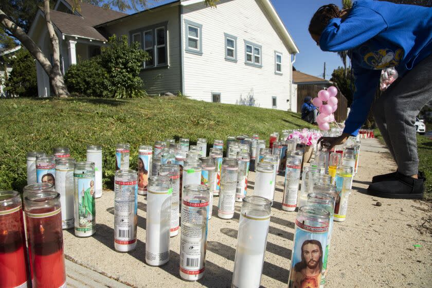 INGLEWOOD, CA - JANUARY 24: Friends of the victim visit a sidewalk memorial at the corner of Brett Street and Park Avenue on Monday, Jan. 24, 2022 in Inglewood, CA, a block from the shooting scene. An early Sunday morning shooting during a birthday party killed four people and wounded a fifth person. (Myung J. Chun / Los Angeles Times)