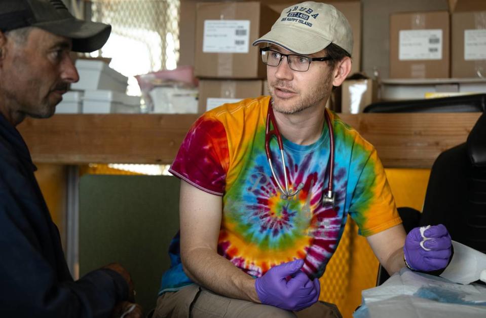 Valley Streetz Harm Reduction physician Dr. James Kraus, right, helps James Black with an open wound at The Rock Church in Modesto, Calif., Friday, April 12, 2024. The program provides harm reduction services and medical treatment at the church on Friday mornings.