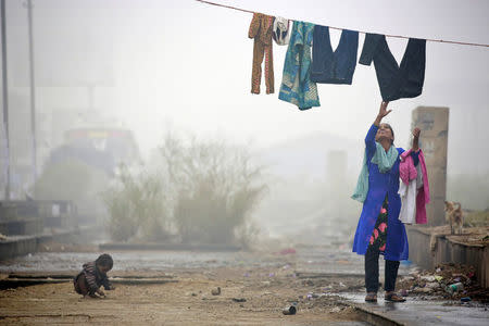 A woman collects her washing during heavy fog in Delhi, India December 1, 2016. REUTERS/Cathal McNaughton