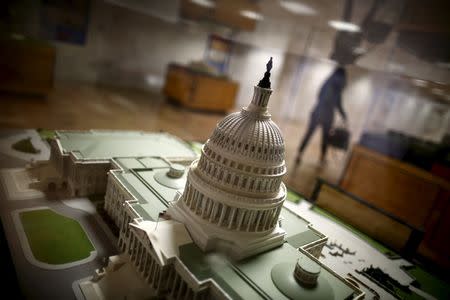 A woman walks by a miniature of the Capitol building at the Hart Senate Office Building at Capitol Hill in Washington, January 20, 2016.REUTERS/Carlos Barria