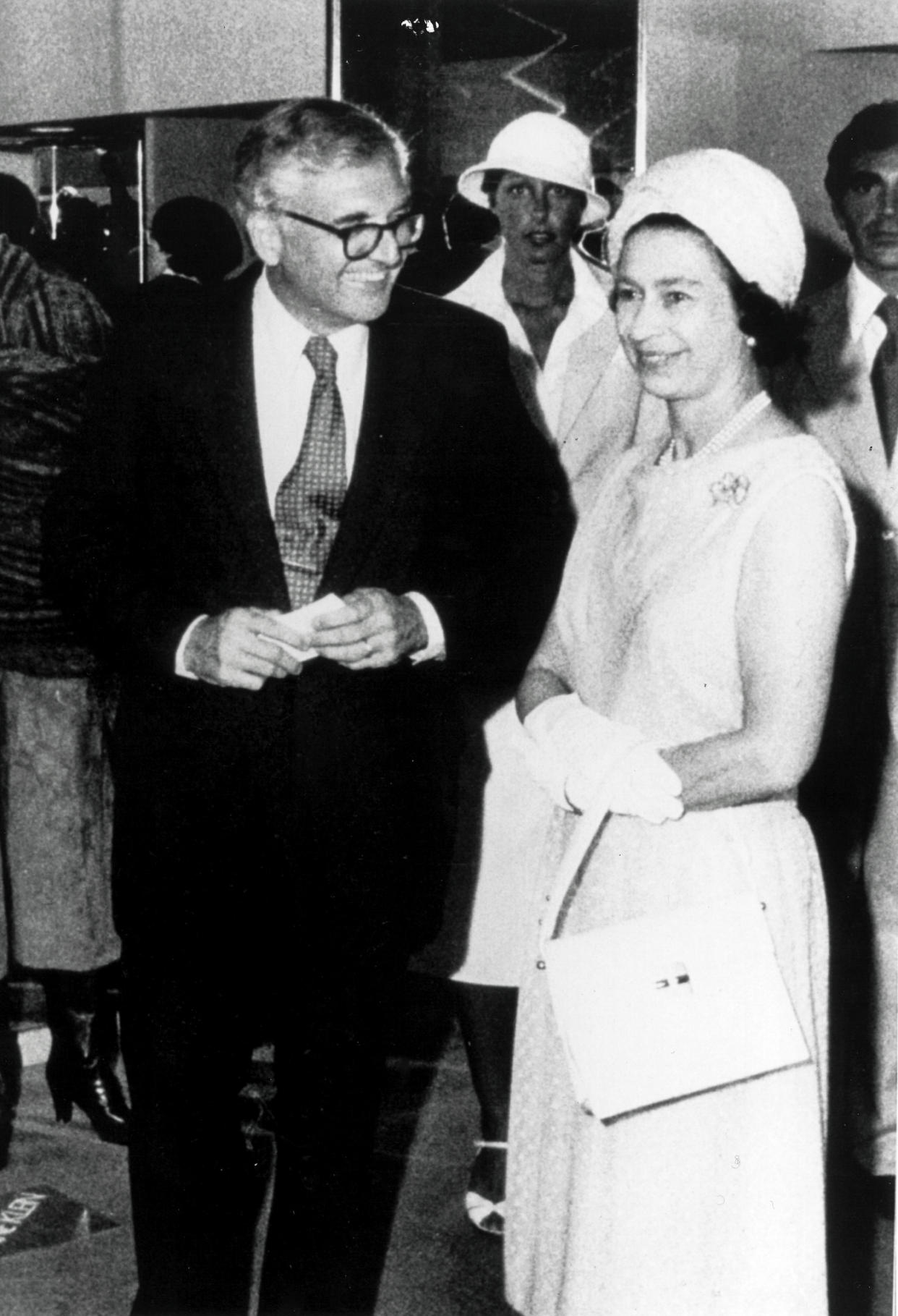 Marvin Traub with Queen Elizabeth II during her visit to Bloomingdales in 1976. Designers Donna Karan and Louis Dell Olio stand in the background.
