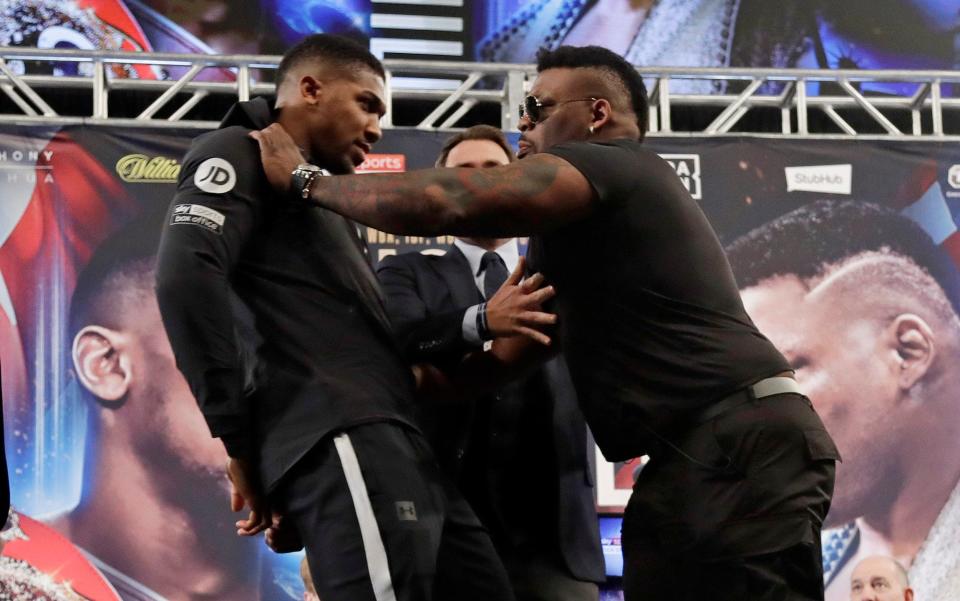 Anthony Joshua, left, is shoved by Jarrell Miller - AP