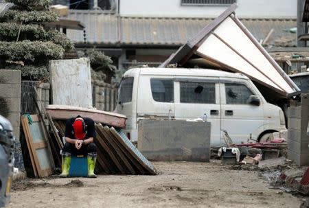 A local resident pauses as he tries to clear mud and debris at a flood affected area in Mabi town in Kurashiki, Okayama Prefecture, July 13, 2018. REUTERS/Issei Kato