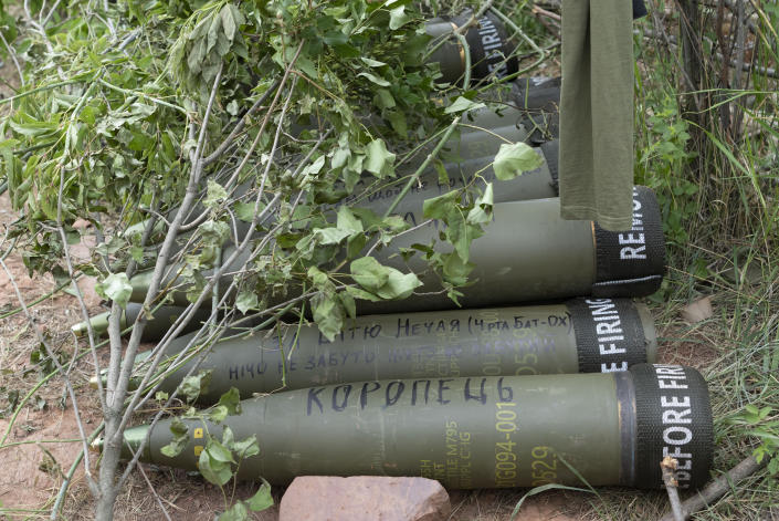 FILE - U.S.-supplied M777 howitzer shells lie on the ground to fire at Russian positions in Ukraine's eastern Donbas region June 18, 2022. Writing on one of them reads: "Nothing is forgotten". U.S. officials will send another $450 million in military aid to Ukraine. (AP Photo/Efrem Lukatsky, File)