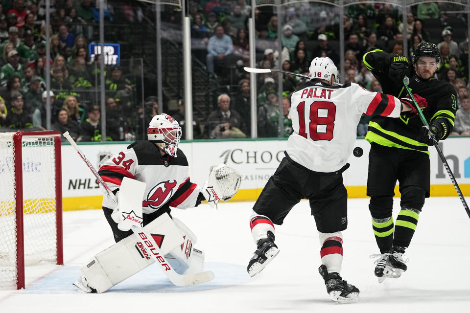 New Jersey Devils' Jake Allen (34) and Ondrej Palat (18) defend the net as Dallas Stars' Sam Steel, right, attempts to clear out for a shot in the first period of an NHL hockey game in Dallas, Thursday, March 14, 2024. (AP Photo/Tony Gutierrez)