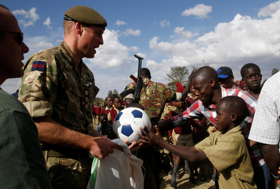 The Duke of Cambridge, Prince William (L) gives sports equipment to pupils during his visit Ol Maiso primary school in Laikipia, Kenya September 30, 2018. REUTERS/Thomas Mukoya