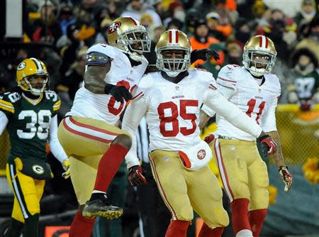 Jan 5, 2014; Green Bay, WI, USA; San Francisco 49ers tight end Vernon Davis (85) celebrates a touchdown with wide receiver Anquan Boldin (81) and wide receiver Quinton Patton (11) in the 4th quarter as Green Bay Packers cornerback Tramon Williams (38) looks on during the 2013 NFC wild card playoff football game at Lambeau Field. The 49ers beat the Packers 23-20. Mandatory Credit: Benny Sieu-USA TODAY Sports