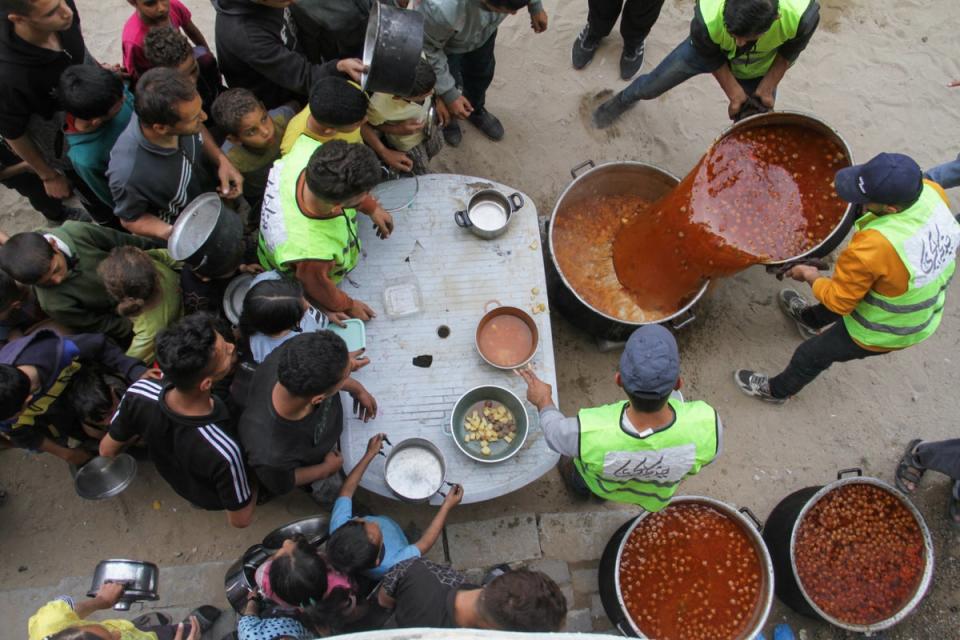 Volunteers deliver food to families in Gaza in April 2024. At least 35,000 people have been killed in Gaza since 7 October 2023 (Reuters)