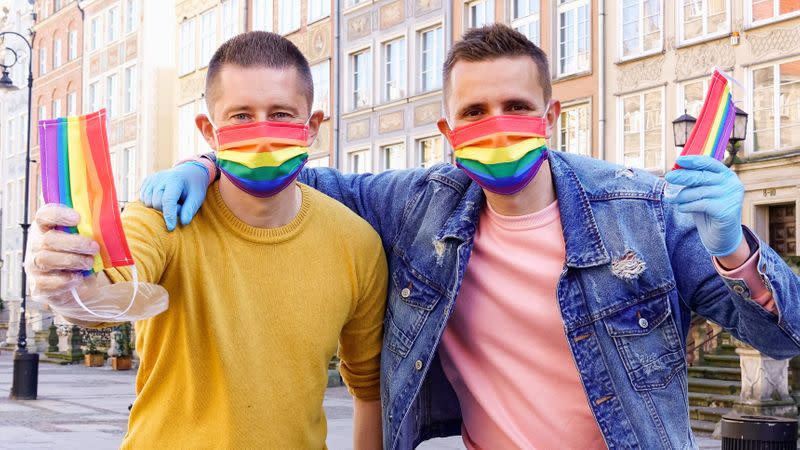 Gay couple Dawid Mycek and Jakub Kwiecinski pose with the rainbow-patterned face masks on a street in Gdansk