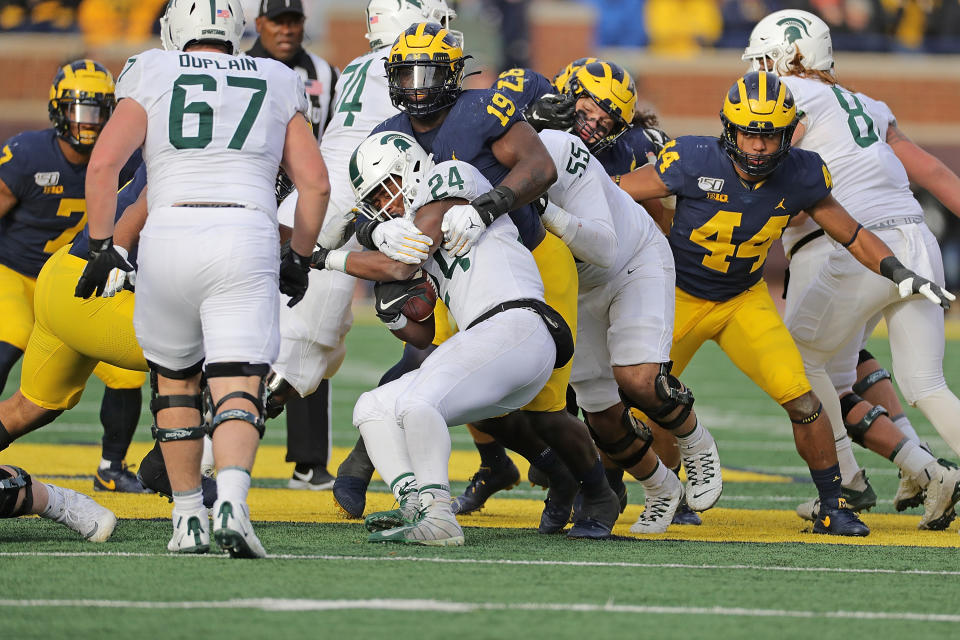 Kwity Paye #19 of the Michigan Wolverines makes the stop on Elijah Collins #24 of the Michigan State Spartans during the second quarter of the game at Michigan Stadium on Nov. 16, 2019 in Ann Arbor, Michigan. Michigan defeated Michigan State 40-10. Leon Halip/Getty Images