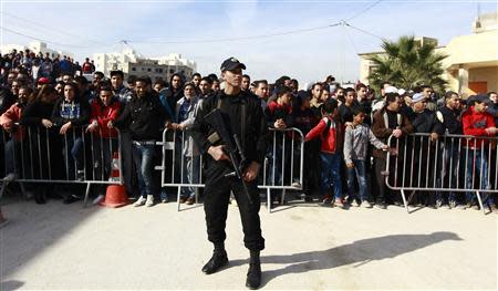 A policeman stands guard near a house in Raoued, a northern suburb of the capital Tunis, February 4, 2014. REUTERS/Anis Mili