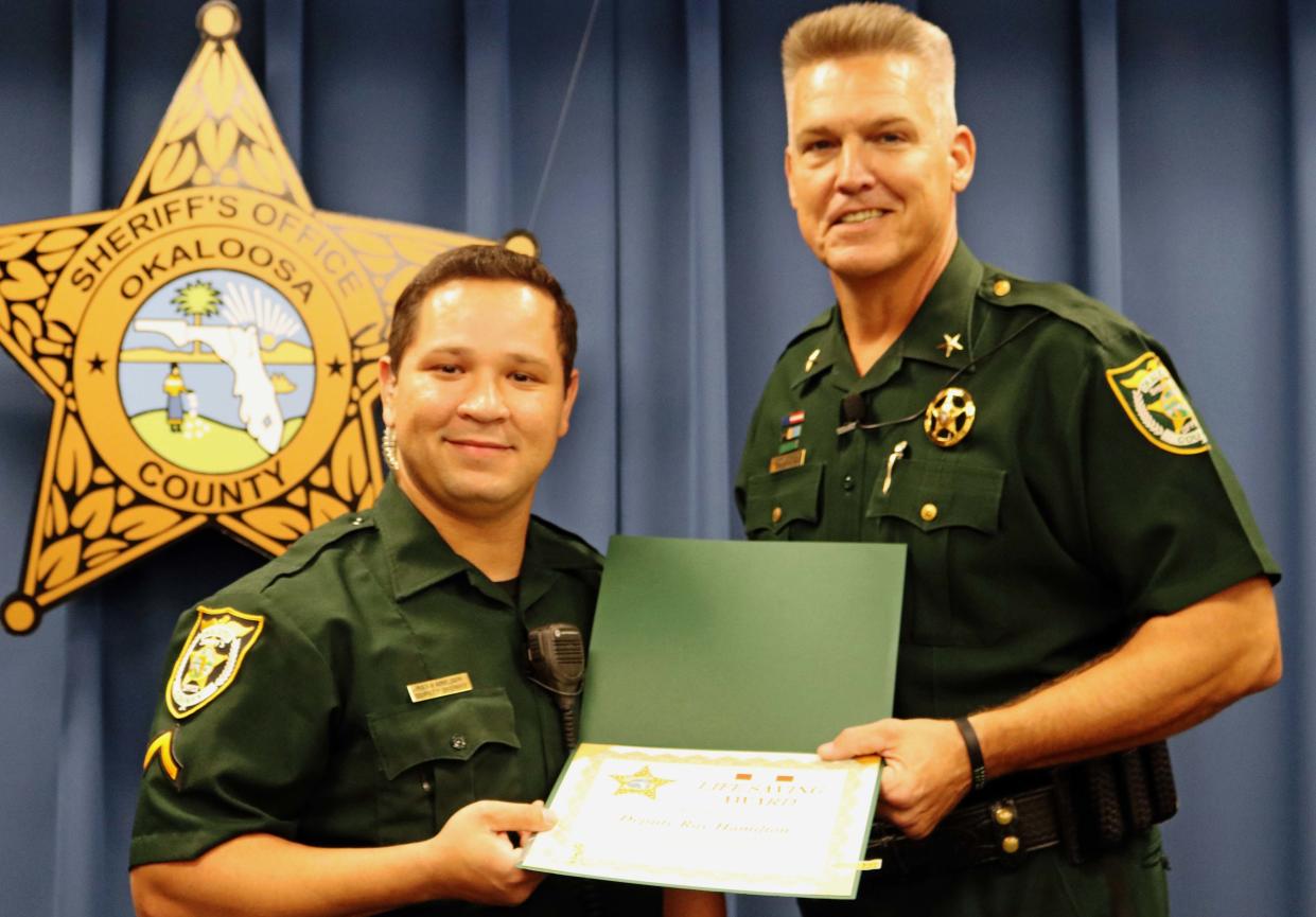 Corporal Ray Hamilton is presented with a Life Saving Award by former Okaloosa County Sheriff Larry Ashley, one of two during his five-year career with the Okaloosa County Sheriff’s Office.