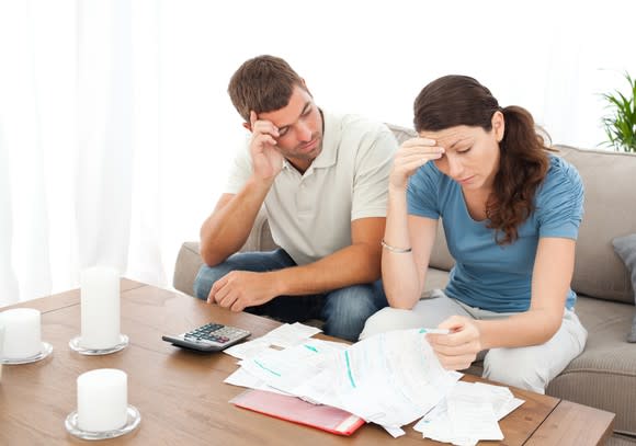 Couple looking at documents and appearing concerned.