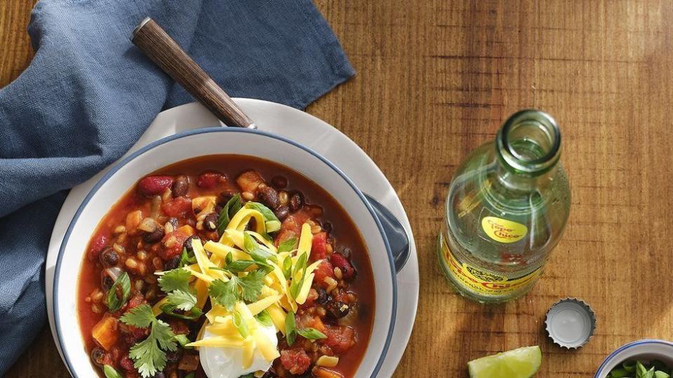 two bowls of vegetarian chili with sour cream and shredded cheese and cilantro no top