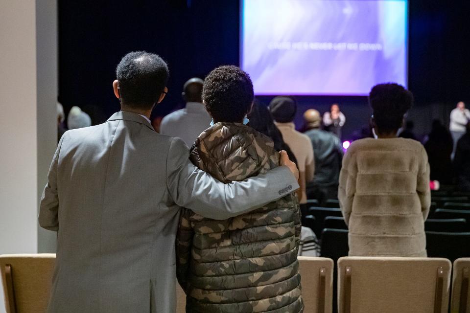 Mengsteab Aregay Gebremariam (left) puts an arm around his 14-year-old son Mikias during Sunday service at Lakeview Church on Jan. 16, 2022, in Indianapolis.