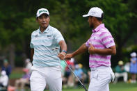 Hideki Matsuyama, of Japan, and Xander Schauffele, right, congratulate themselves after their eagles on the 15th hole during the third round of the Masters golf tournament on Saturday, April 10, 2021, in Augusta, Ga. (AP Photo/Matt Slocum)