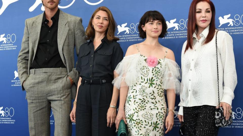 jacob elordi, sofia coppola, cailee spaeny, and priscilla presley standing together for a photo in front of a blue and white background