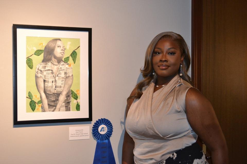 Perri Payne, an 11th-grader at Paul W. Bryant High School in Cottondale, stands next  a piece of art she created titled, 'Honeysuckle.' Payne won the 2023 Congressional District Art Competition for District 7 for a piece titled, 'A Glimpse Into the Future.'