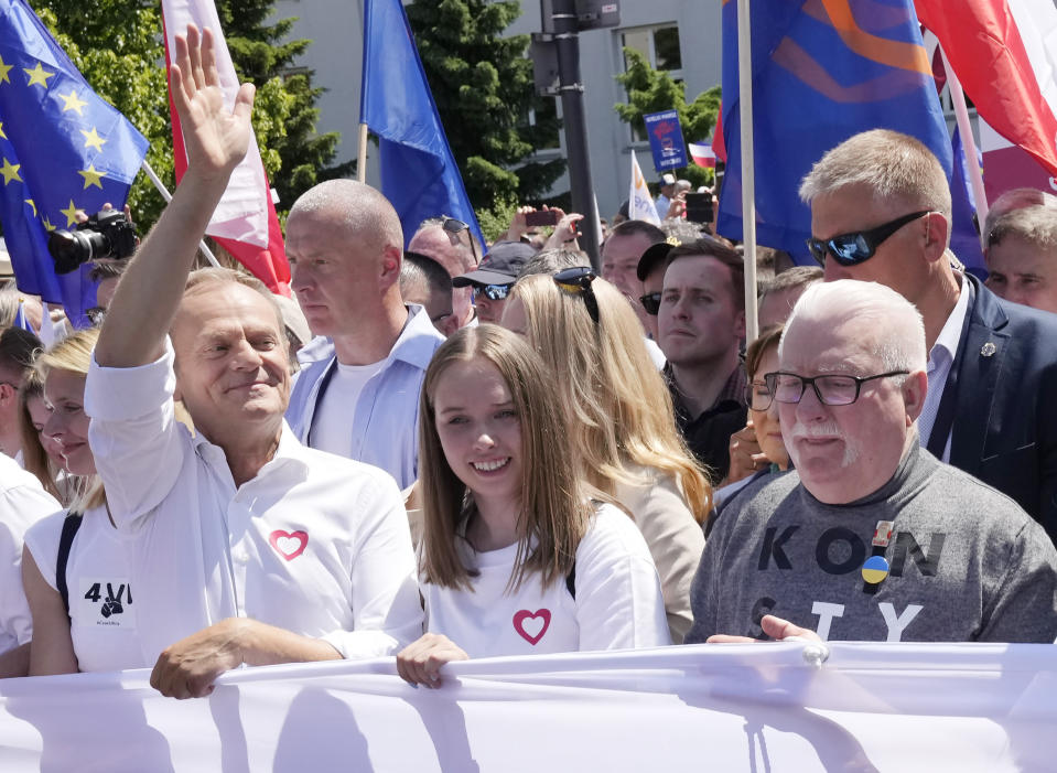 FILE - Participants join an anti-government march led by the centrist opposition party leader Donald Tusk, left, and Lech Walesa, right, who along with other critics accuse the government of eroding democracy, in Warsaw, Poland, on June 4, 2023. Poland’s conservative governing party was hoping to make migration a key campaign theme ahead of the country’s national election. But not like this. The Law and Justice party is being rocked by reports that Polish consulates issued visas in Africa and Asia in exchange for bribes, opening the door for migrants to enter the European Union. . (AP Photo/Czarek Sokolowski)