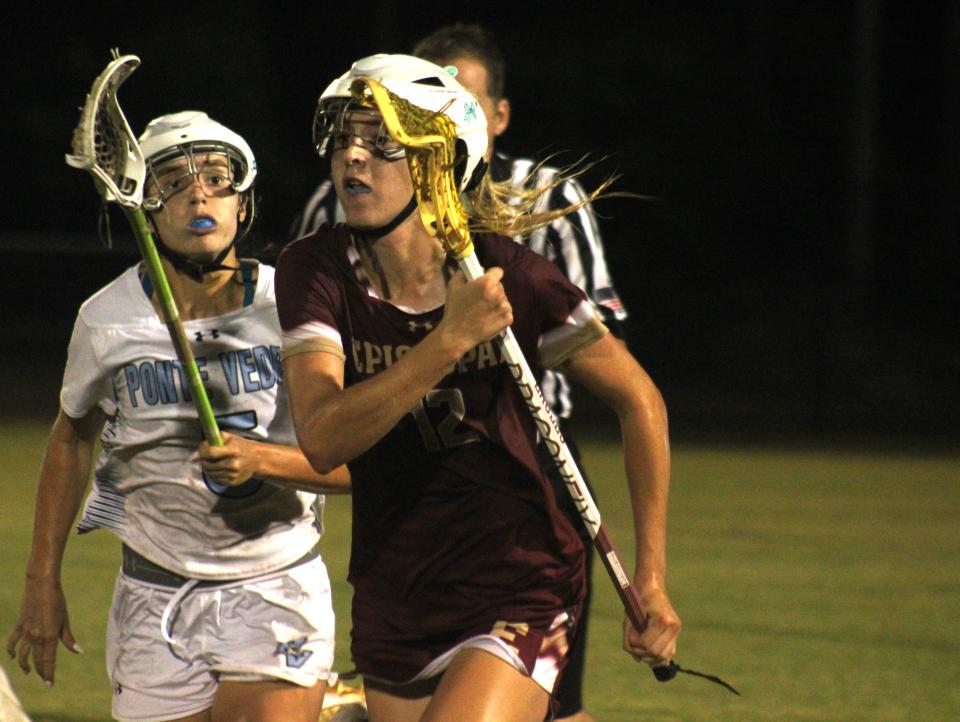 Episcopal midfielder Brooke McCoy (12) advances upfield as Ponte Vedra's Lily Mosser (5) pursues during Friday's Region 1-1A girls lacrosse final.