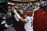 Fans falls onto Philadelphia Eagles quarterback Jalen Hurts (1) as the railing collapsed following the end of an NFL football game, Sunday, Jan. 2, 2022, in Landover, Md. Philadelphia won 20-16. (AP Photo/Alex Brandon)