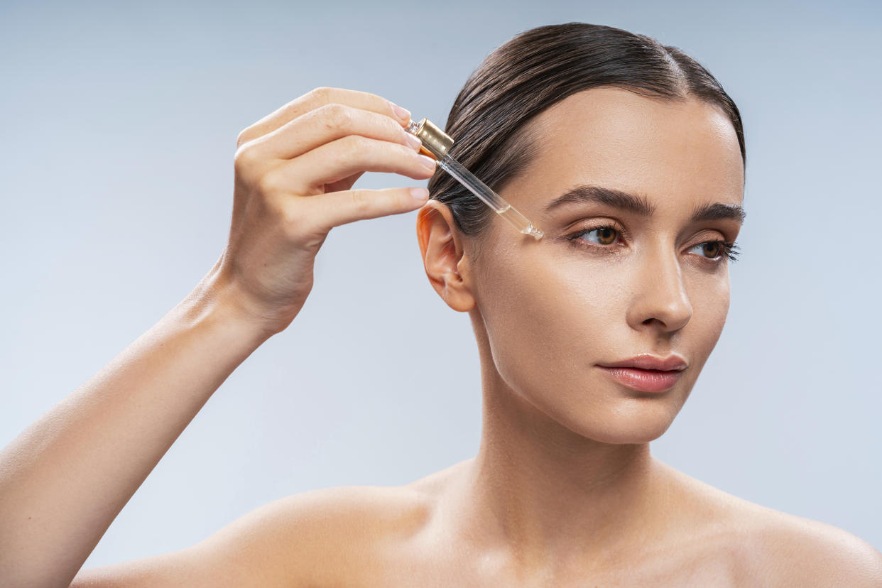 Woman using face oil. (Photo: Gettyimages)