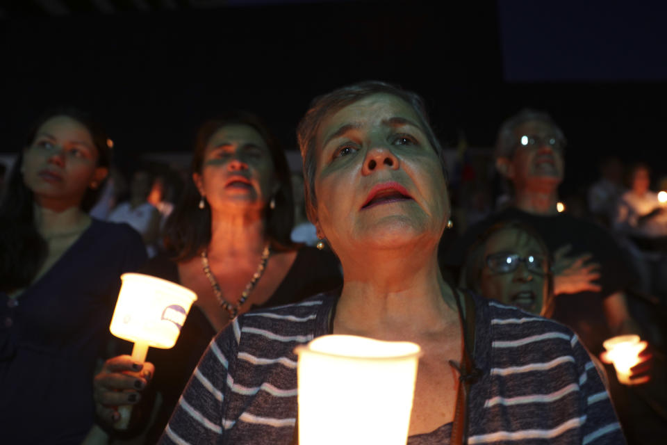 Opponents to Venezuela's President Nicolas Maduro hold a vigil for those killed in street fighting over the past week in Caracas, Venezuela, Sunday, May 5, 2019. Opposition leader Juan Guaid called in vain for a military uprising to overthrow President Nicolas Maduro, and five people were killed in clashes between protesters and police. (AP Photo/Martin Mejia)
