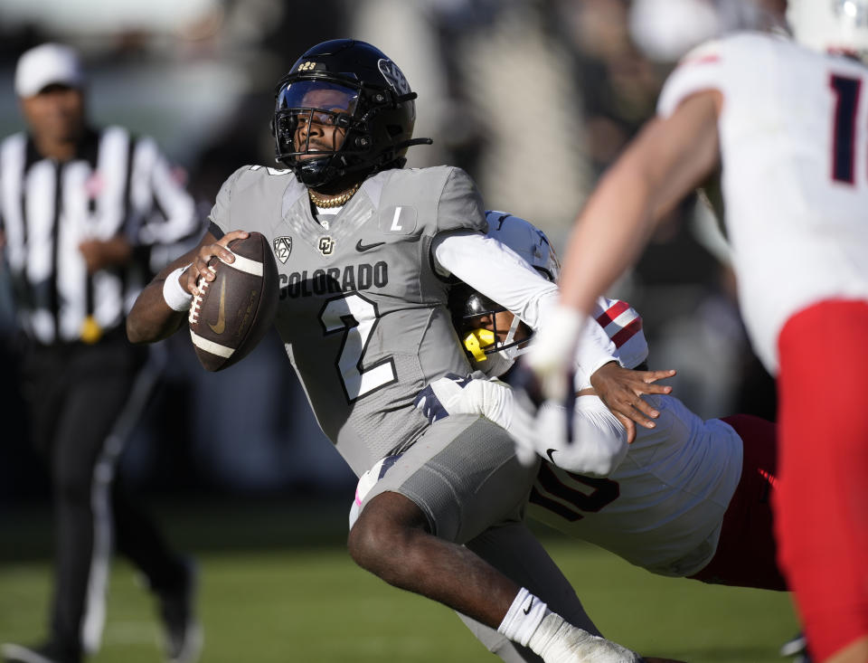 Colorado quarterback Shedeur Sanders (2) is tackled by Arizona linebacker Justin Flowe after a short gain in the second half of an NCAA college football game on Saturday, Nov. 11, 2023, in Boulder, Colo. (AP Photo/David Zalubowski)