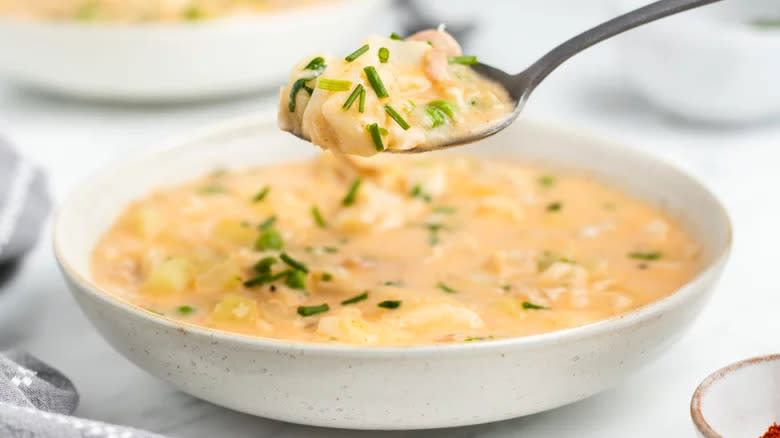 Creamy fish soup in bowl with spoon