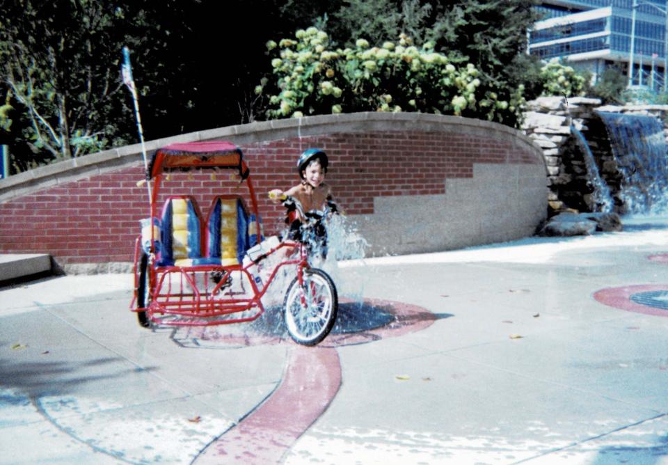 Jacob Pais rides a Sikod-Sikod (pedicab) through the fountain at Volunteer Landing in summer 1998, exclaiming “This is the best day of my life!”