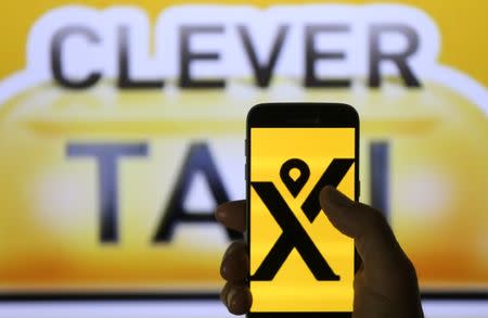 My Taxi logo are seen on the smartphone in front of displayed Cleaver Taxi logo in this illustration taken June 22, 2017. REUTERS/Dado Ruvic