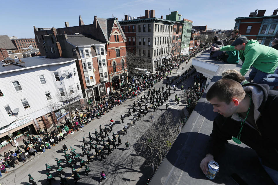 People watch the annual St. Patrick's Day parade from a roof in the South Boston neighborhood of Boston, Sunday, March 16, 2014. (AP Photo/Michael Dwyer)