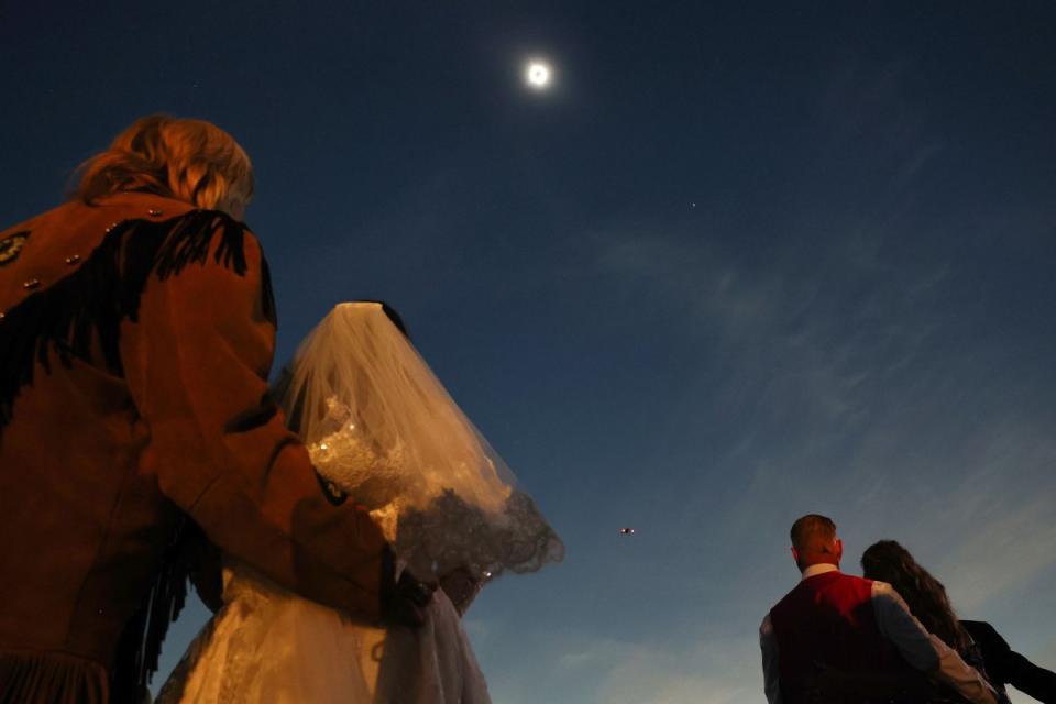 Couples view the solar eclipse during totality at a mass wedding at the Total Eclipse of the Heart festival in Russellville, Ark.<span class="copyright">Mario Tama—Getty Images</span>