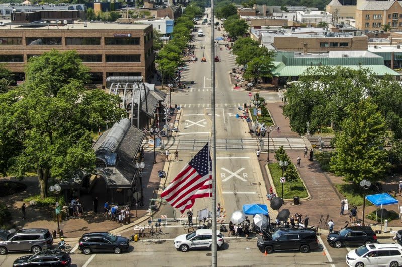 An aerial photo shows an American flag at half-staff as law enforcement officers investigated the scene of a mass shooting in Highland Park, Ill., on July 5, 2022. Robert Crimo Jr., the father of the alleged gunmen, pleaded guilty to seven misdemeanor counts on Monday. File Photo by Tannen Maury/EPA-EFE