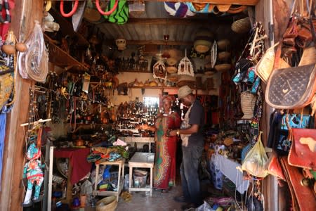 Tourist looks at good in a craft shop in the historic slave port of Ouidah, Benin