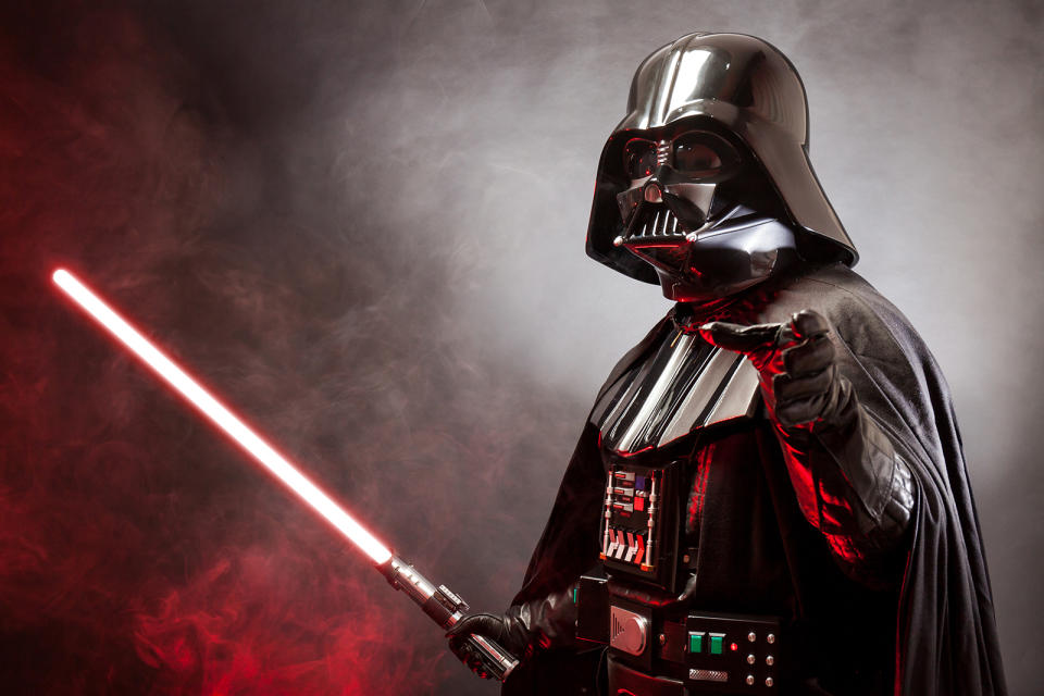 Portrait of Darth Vader costume replica with grab hand and his red sword. 