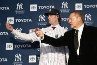 Gerrit Cole, left, and his agent Scott Boras gesture as he is introduced as the newest New York Yankees player during a baseball media availability, Wednesday, Dec. 18, 2019 in New York. The pitcher agreed to a 9-year $324 million contract. (AP Photo/Mark Lennihan)